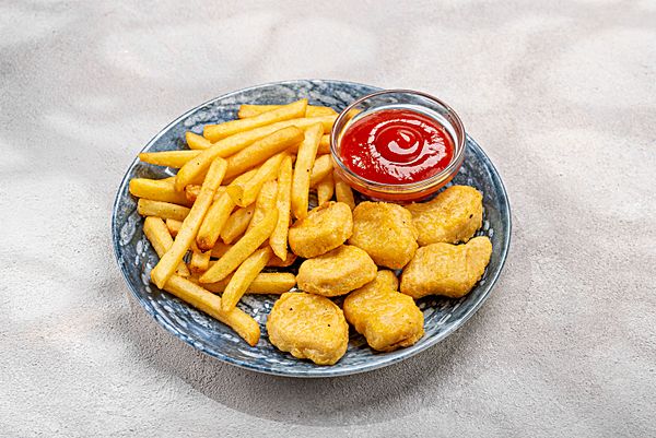 Куриные нагетсы с картофелем фри и кетчупом