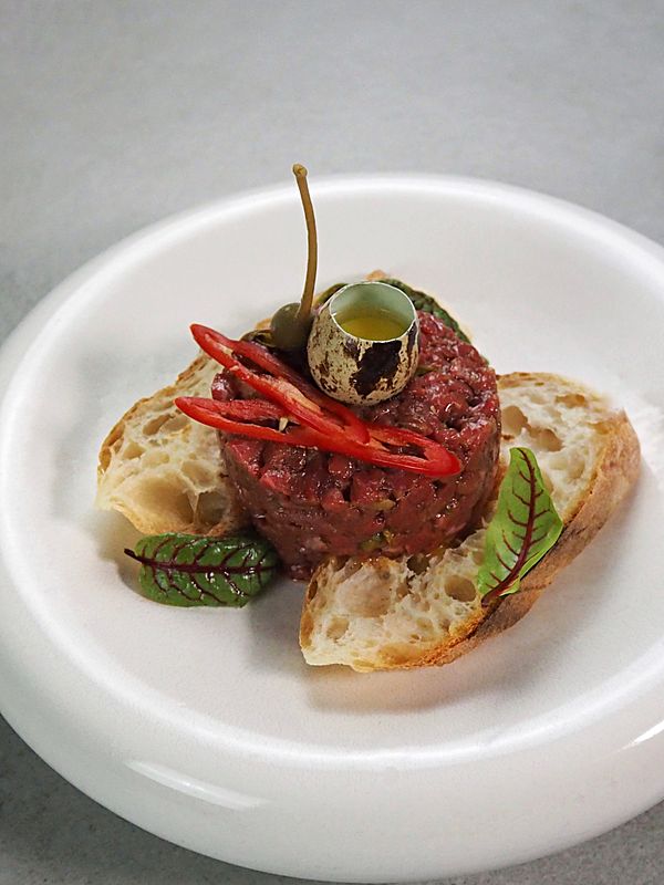 Тартар из телятины на хлебных тостах с каперсами и перепелиным яйцом