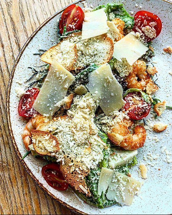 Цезарь с жареными креветками, хрустящими гренками, листом салата и сыром пармезан