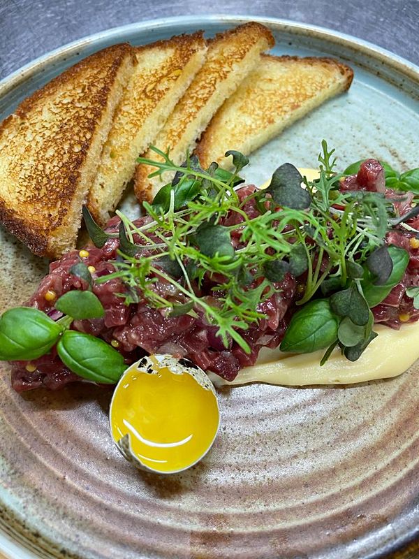 Тартар из говядины, перепелиное яйцо, бриошь, крем Пармезан