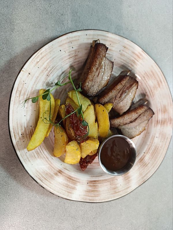 Ребра свиные с перечным соусом, картофельными дольками и вяленными томатами