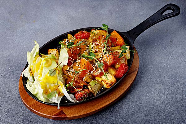 Сковорода с печеными овощами, паниром и листьями айсберга