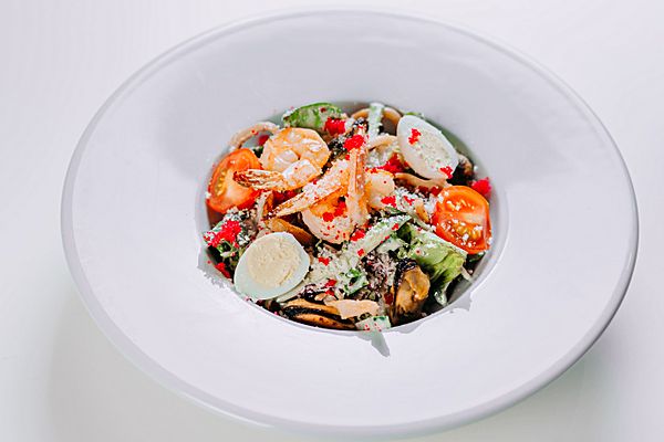 Салат с морепродуктами, томатами черри, перепелиным яйцом, свежим огурцом под сыром пармезан