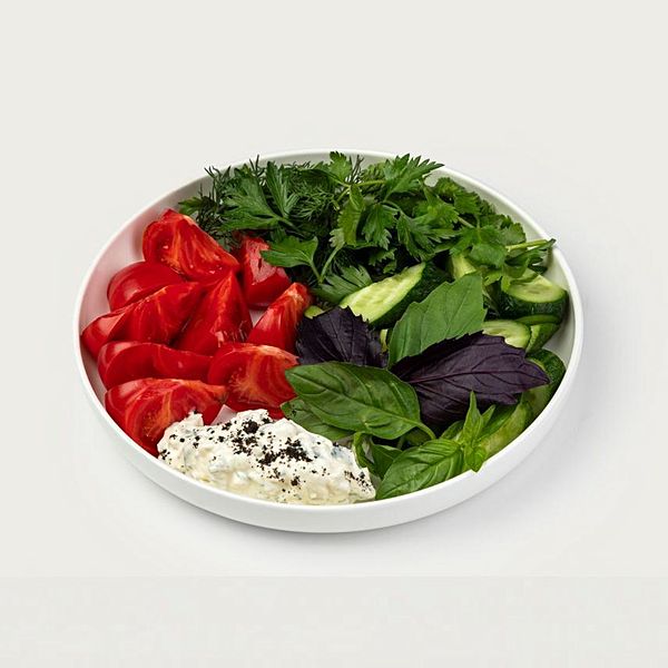 Розовые томаты и огурцы с чесночным соусом и карибикой