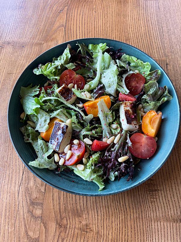 Салат с сыром халуми, томатами, сезонными фруктами и свежей карамелизированной грушей